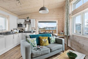 Eine moderne Küche mit weißen Schränken und einem Essbereich mit Holztisch und Stühlen.