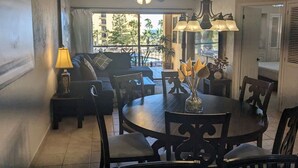 Un espace repas comprenant une table ronde, des chaises, un lustre et un ventilateur de plafond.