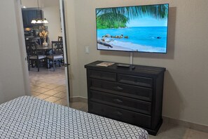 A bedroom with a bed, a TV mounted on a wall, and a dresser. - Ocean Front Resort 2-Bedroom Condo at Princesa de Peñasco with Amenities (Puerto PeÃ±asco)