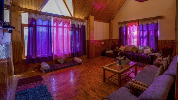 A cozy living room with wooden floors, a sofa, a coffee table, and a TV.