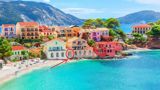 Un pueblo costero con edificios de colores, una playa y aguas azules cristalinas.