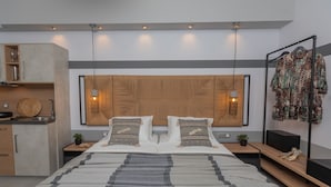 Un dormitorio moderno con una cama grande, cabecera de madera, mesitas de noche y una lámpara colgante.