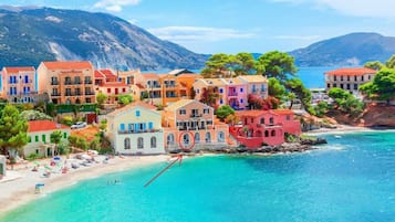 Une ville côtière aux bâtiments aux couleurs vives, avec une plage et une vue dégagée sur la mer.