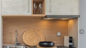 Una cocina moderna con horno empotrado, un lavamanos y armarios de madera.