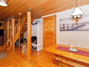 A wooden interior with a fireplace, a bench, and a staircase. - Kaakkuri by Interhome (Lieksa)