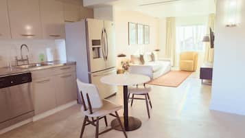 A modern kitchen with a dining area, a sofa, and a chair.