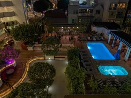 Una piscina al aire libre, camas de piscina con cargo, sombrillas