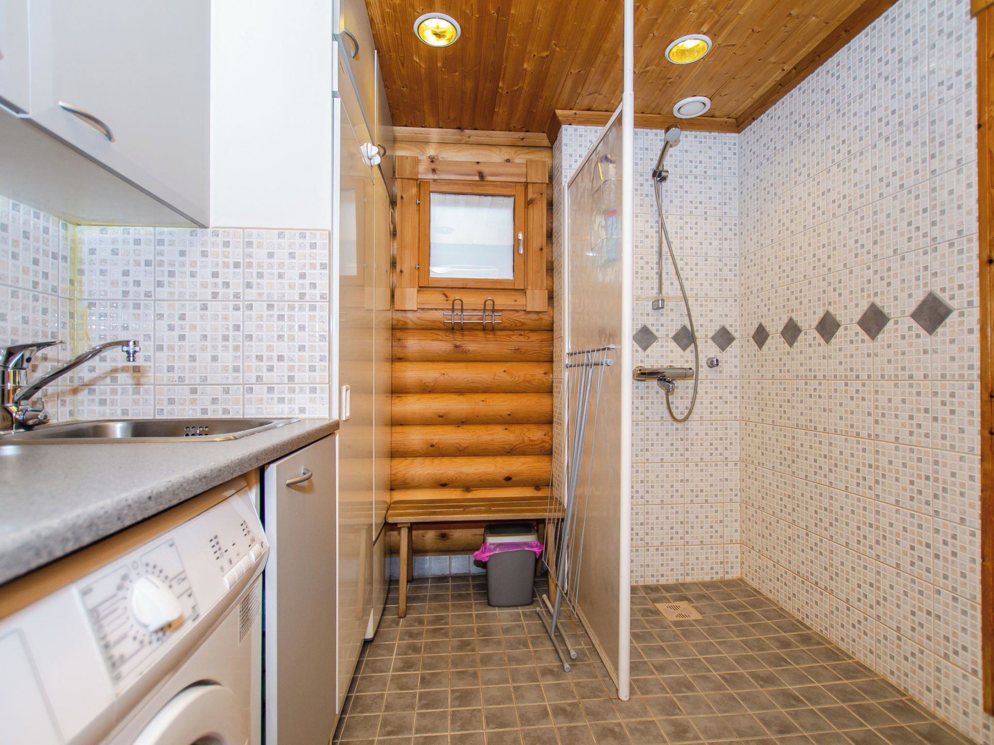 A compact kitchen with a sink, cabinets, and a window.