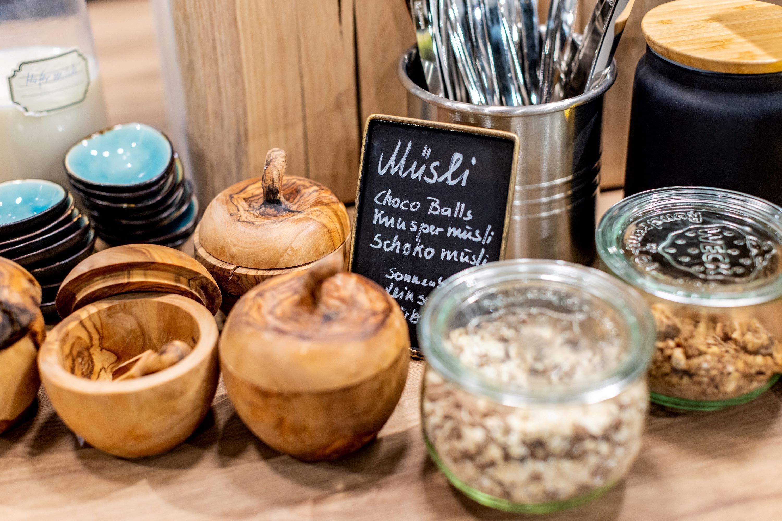Diversos cuencos y frascos de madera, algunos con tapas, dispuestos sobre una superficie de madera.