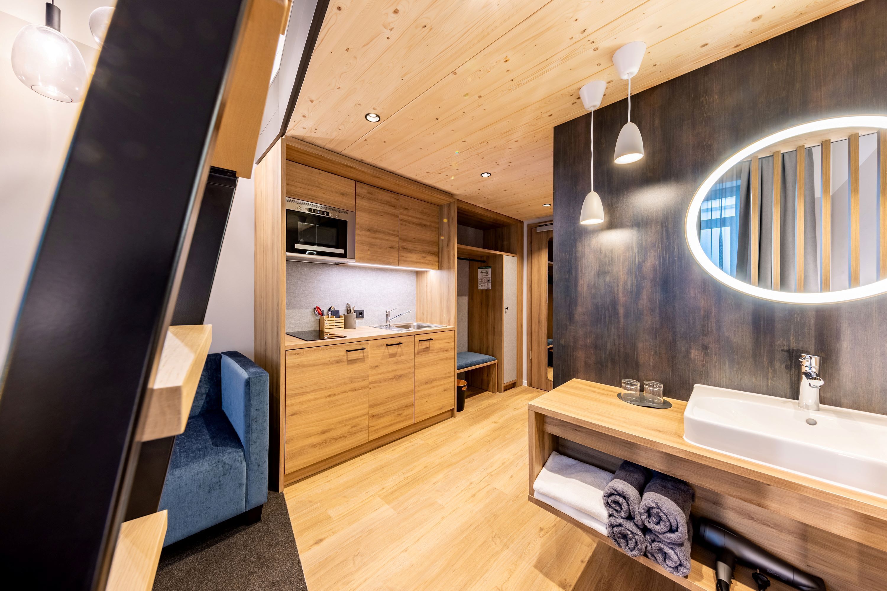 Une cuisine moderne avec des meubles en bois, un four à micro-ondes et un four encastré.