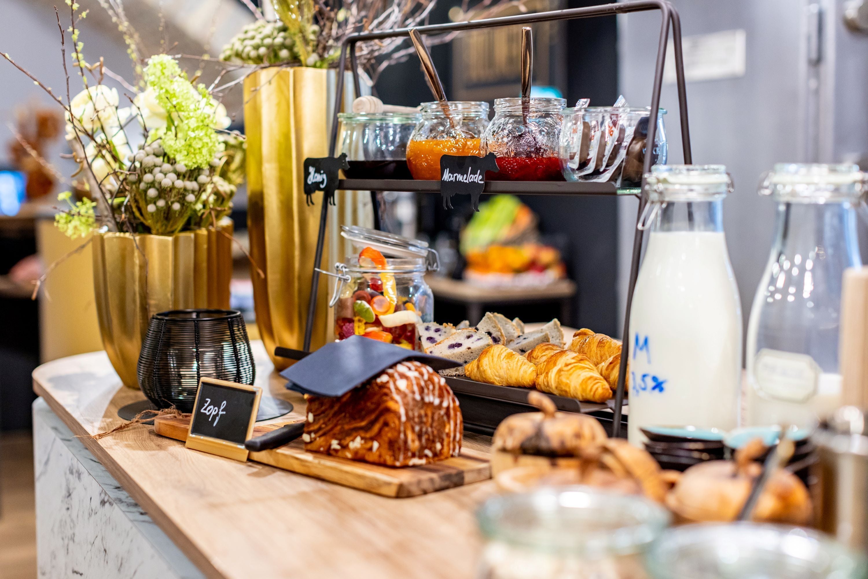 Ein reichhaltiges Frühstücksbuffet mit einer Auswahl an Speisen, darunter Backwaren, Früchten und Getränken.