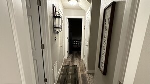 A hallway with white walls, a wooden floor, and a door on the right labeled "RESORT." - Nisswa Lake Hubert Cabin on Paul Bunyan Trail ~In the heart of Brainerd Lakes~ (Nisswa)