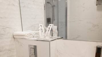 Ein modernes Badezimmer mit Toilette, Waschbecken und einer Duschkabine aus Glas.