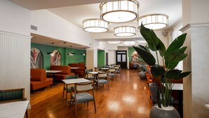 A spacious lobby with wooden flooring, multiple seating areas including booths and tables, and large hanging lamps. - Best Western Plus Oskemen (Oskemen)