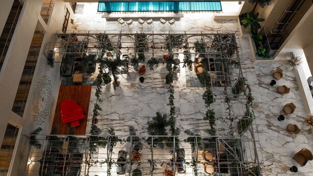 A multi-level atrium with a central garden area, multiple balconies, and a blue awning. - Best Western Plus Oskemen (Oskemen)