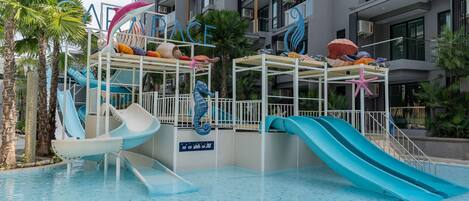 Zona de piscina con toboganes, palmeras y un letrero que dice "PACE".
