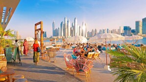 Un bar sul tetto con posti a sedere all'aperto, con vista sullo skyline cittadino.