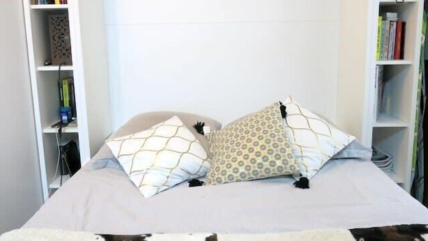 A bedroom with a bed, two pillows, a blanket, and bookshelves on either side. - Charme Belfort CityCosy (Vincennes)
