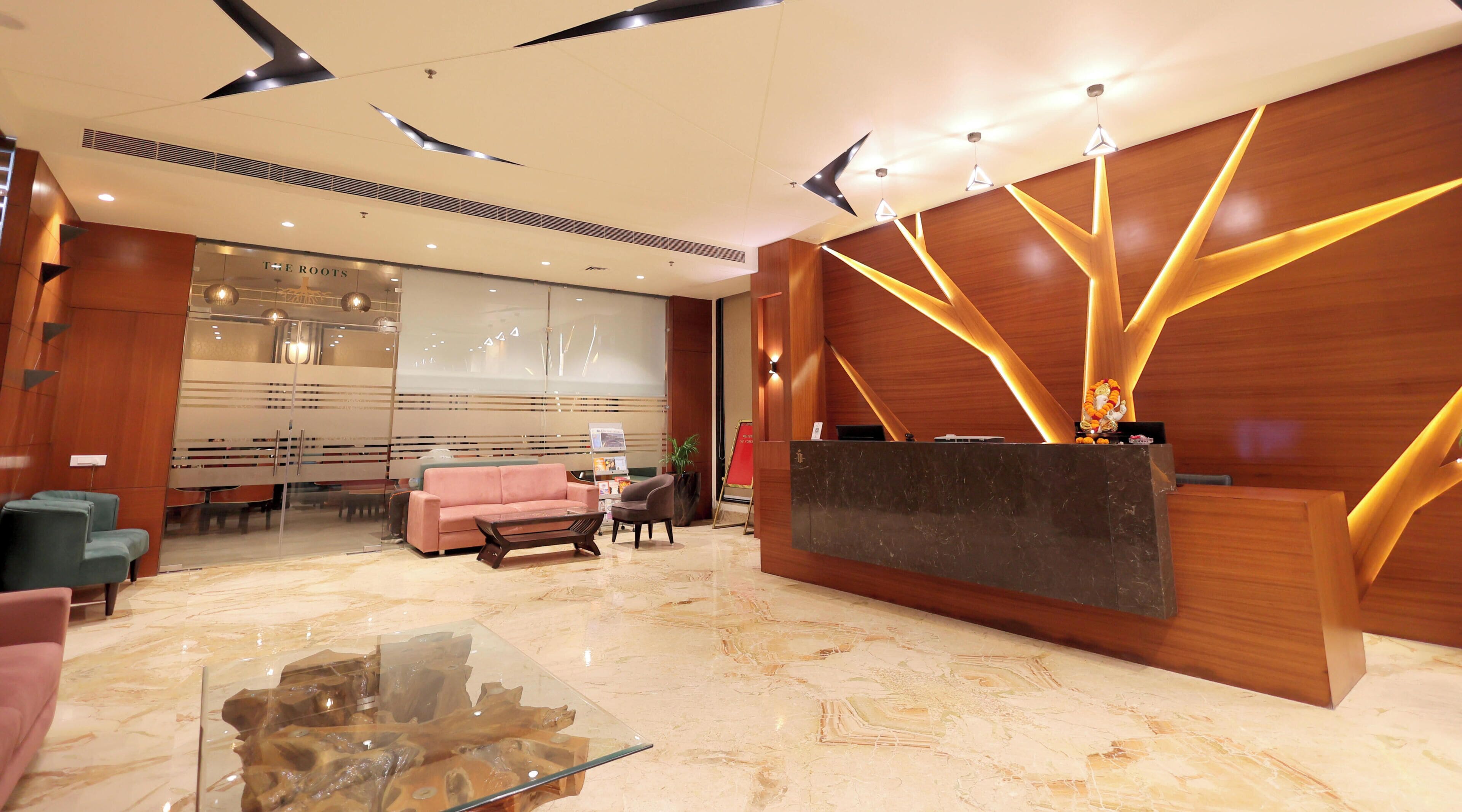 A modern reception area with a marble reception desk, a pink sofa, and a glass coffee table.