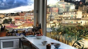 A kitchen with a view of a cityscape through a large window. - Le terrazze di Chiaia is a charming penthouse with two large panoramic terraces (Napoli)
