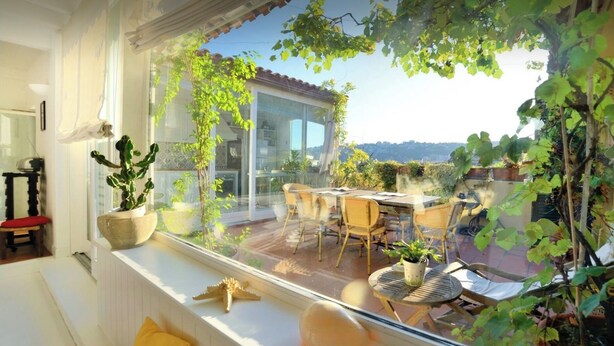 A balcony with a dining area, potted plants, and a view of the cityscape. - Le terrazze di Chiaia is a charming penthouse with two large panoramic terraces (Napoli)