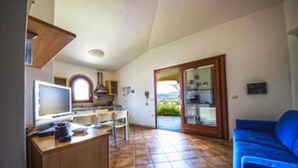 A compact living space with a kitchenette, a dining area, and a seating area with a view.