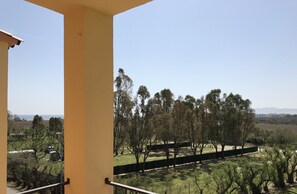 A balcony with a view of a park and distant buildings. - Beach Apartment in L'Estartit (Torroella de Montgrí)
