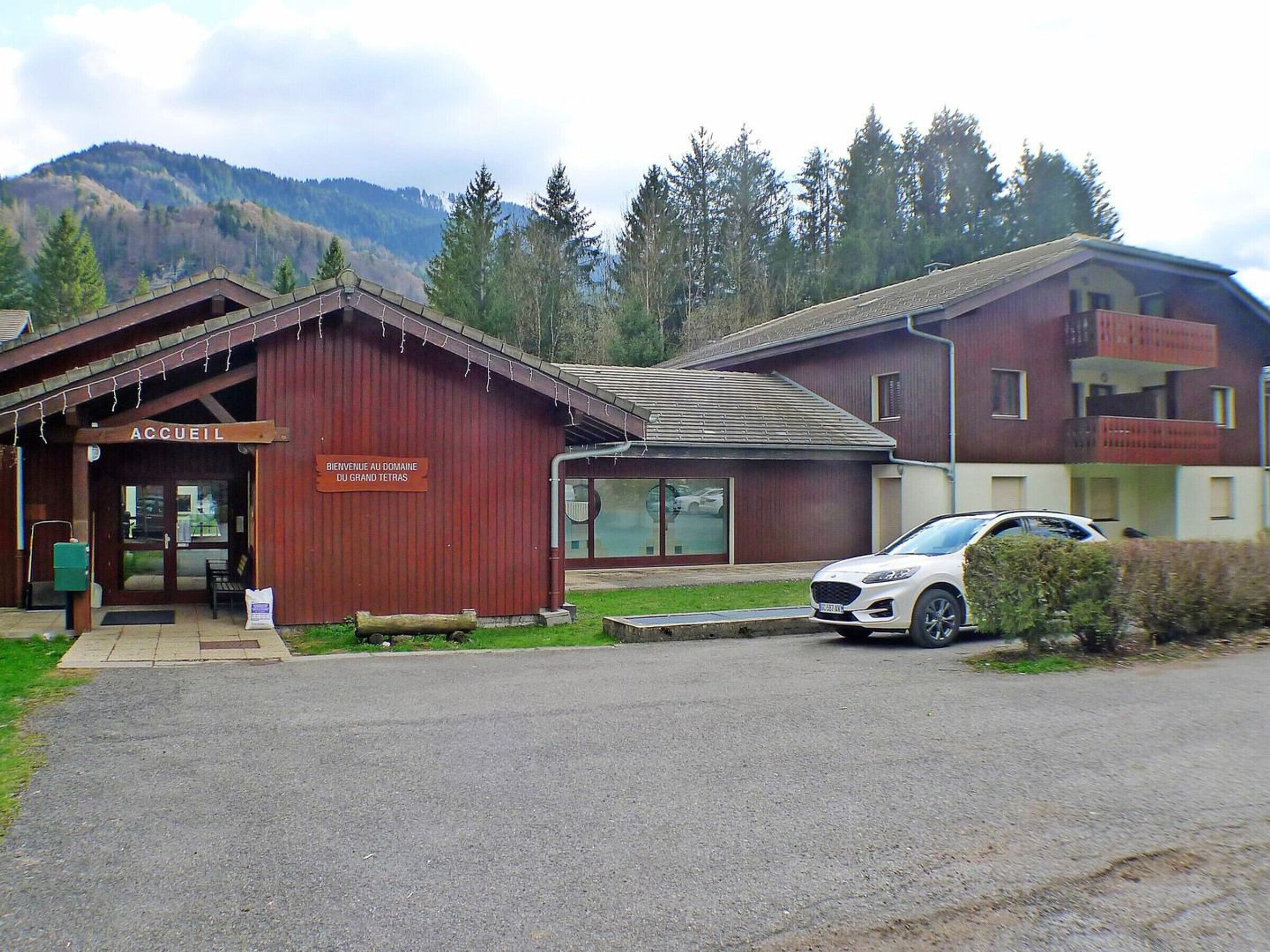 A building with a sign reading "ACCUEL" and "BIENVENUE AU DOMAINE DU GRAND TETRAS".