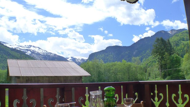 A table set outdoors with a mountain view, a wooden bench, and a metal railing. - 2-room apartment with balcony in Samoëns, parking included (Samoëns)
