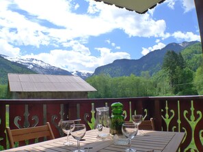 A table set outdoors with a mountain view, a wooden bench, and a metal railing. - 2-room apartment with balcony in Samoëns, parking included (Samoëns)
