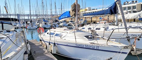 A marina with multiple sailboats docked, including one named 'Santa Maria II'.