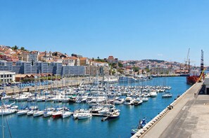 Un port de plaisance où sont amarrés de nombreux bateaux, un ciel dégagé et des bâtiments en arrière-plan.
