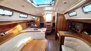 Un intérieur compact et bien éclairé, comprenant un coin cuisine, un espace salon et un panneau de commande.