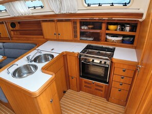 Cocina compacta con estufa, lavamanos y alacenas.