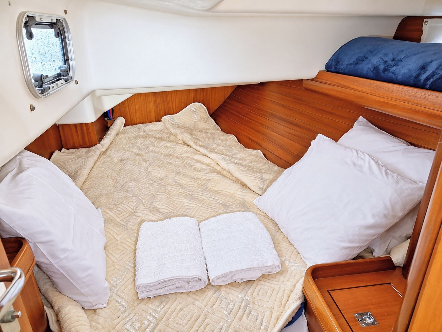A compact cabin with a bed, pillows, and a window.