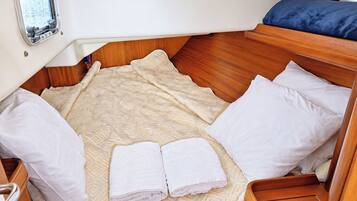 A compact cabin with a bed, pillows, and a window.
