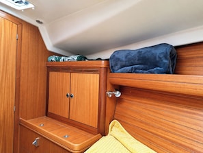 Una cabaña pequeña con muebles de madera, un banco y un estante bajo el techo.