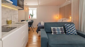 A compact living space with a kitchenette, a dining area, and a bed with a view of the outdoors. - Studio 1 • Downtown Lisbon • Walkable • Balcony (Lisboa)