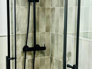 A shower enclosure with a glass door and a black hose. - Luxury Studio with Balcony & Wi-Fi, 450m from Bajondillo Beach in Torremolinos Center (Torremolinos)