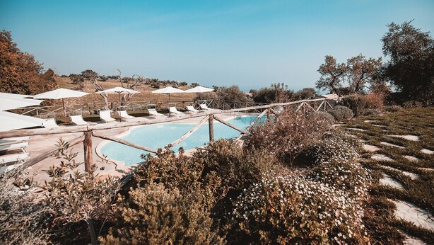 A pool area with white umbrellas and lounge chairs. - Torre di Palme apartment with panoramic terrace and pool -5 minutes from the sea (Marche)