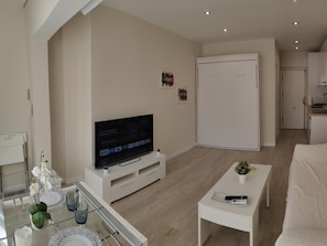 Enjoy a minimalist retreat with a flat-screen TV, dining table, and cozy seating area.