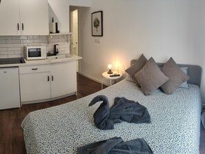 Une chambre à coucher avec un lit, des oreillers et une couverture en forme de cygne.