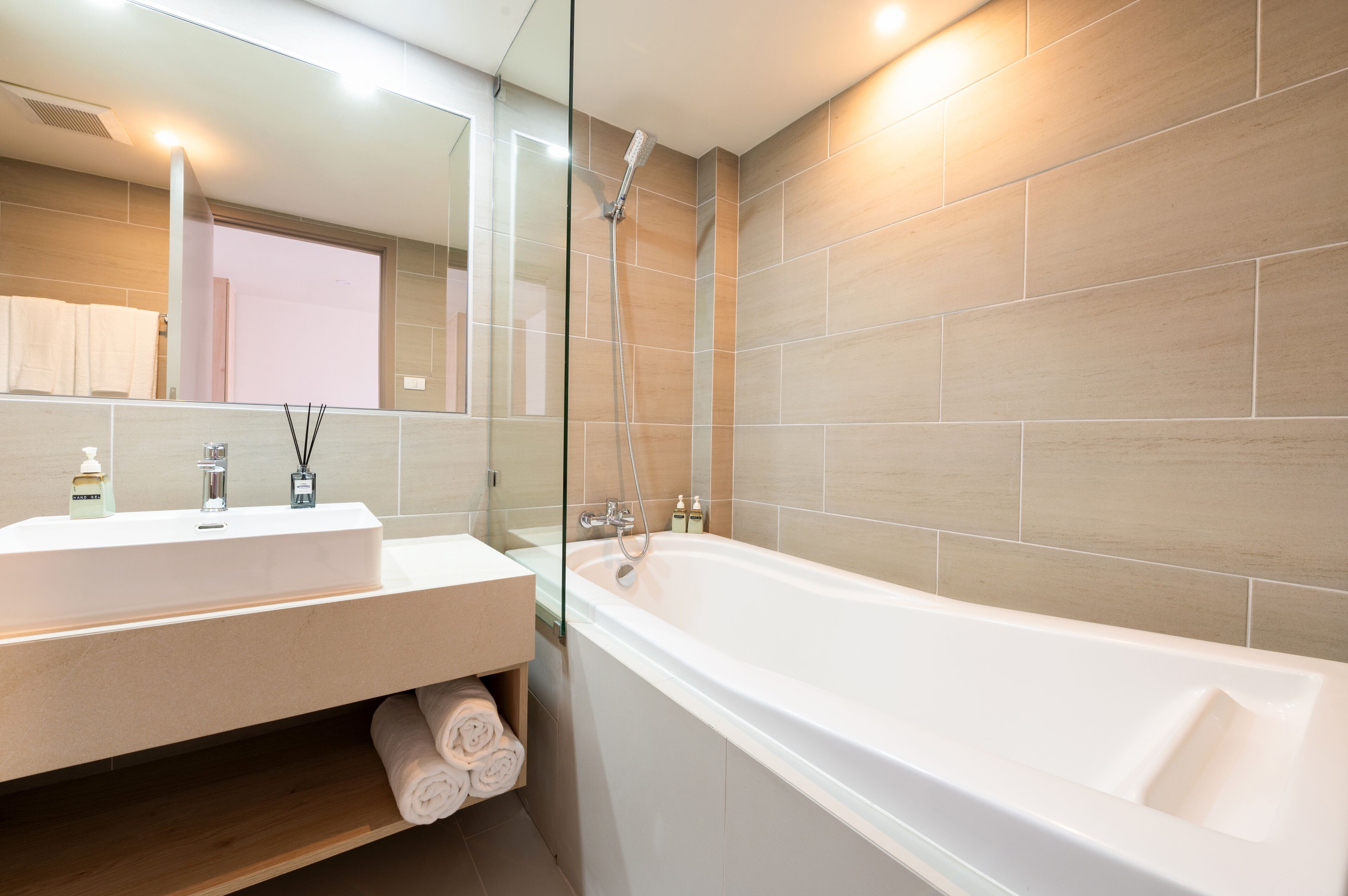 A modern bathroom with a large bathtub, a vanity with a mirror, and a shower.