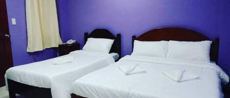 A room with two single beds, a nightstand with a phone, and an air conditioning unit on the wall.