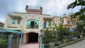 A multi-story building named "CASA VENICIA" with a gated entrance, a balcony with decorative railings, and a surrounding garden. - Casa Venicia Caticlan (Boracay Island)