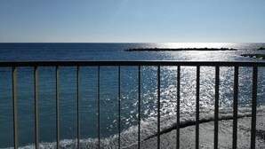 A clear view of the ocean with a distant shoreline and a metal railing in the foreground. - Cristina Home "Town Center" (Sanremo)