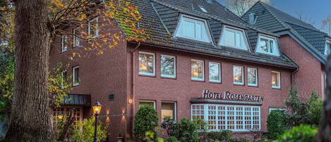 A brick building with a sign reading "Hotel Rosengarten."