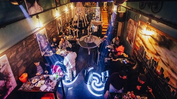 Um restaurante com uma área de estar circular central, rodeada por mesas e cadeiras.