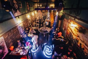 Een restaurant met een centraal, rond zitgedeelte, omringd door tafels en stoelen.