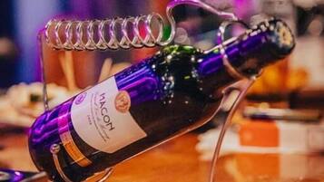 A bottle of Macon wine on a clear glass stand.